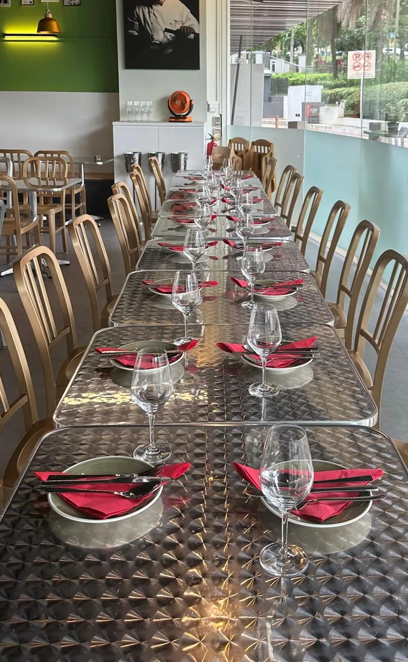 A long table at Schnitzel Haus laid for a private party, with red napkins, wine glasses and place settings running the length of the room