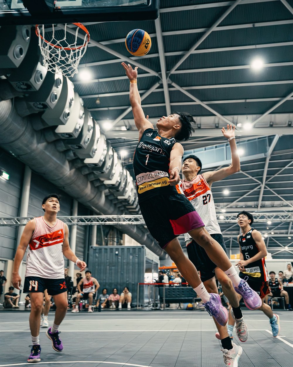 A Wolfgang SG player finishing at the rim as the ball drops through the net